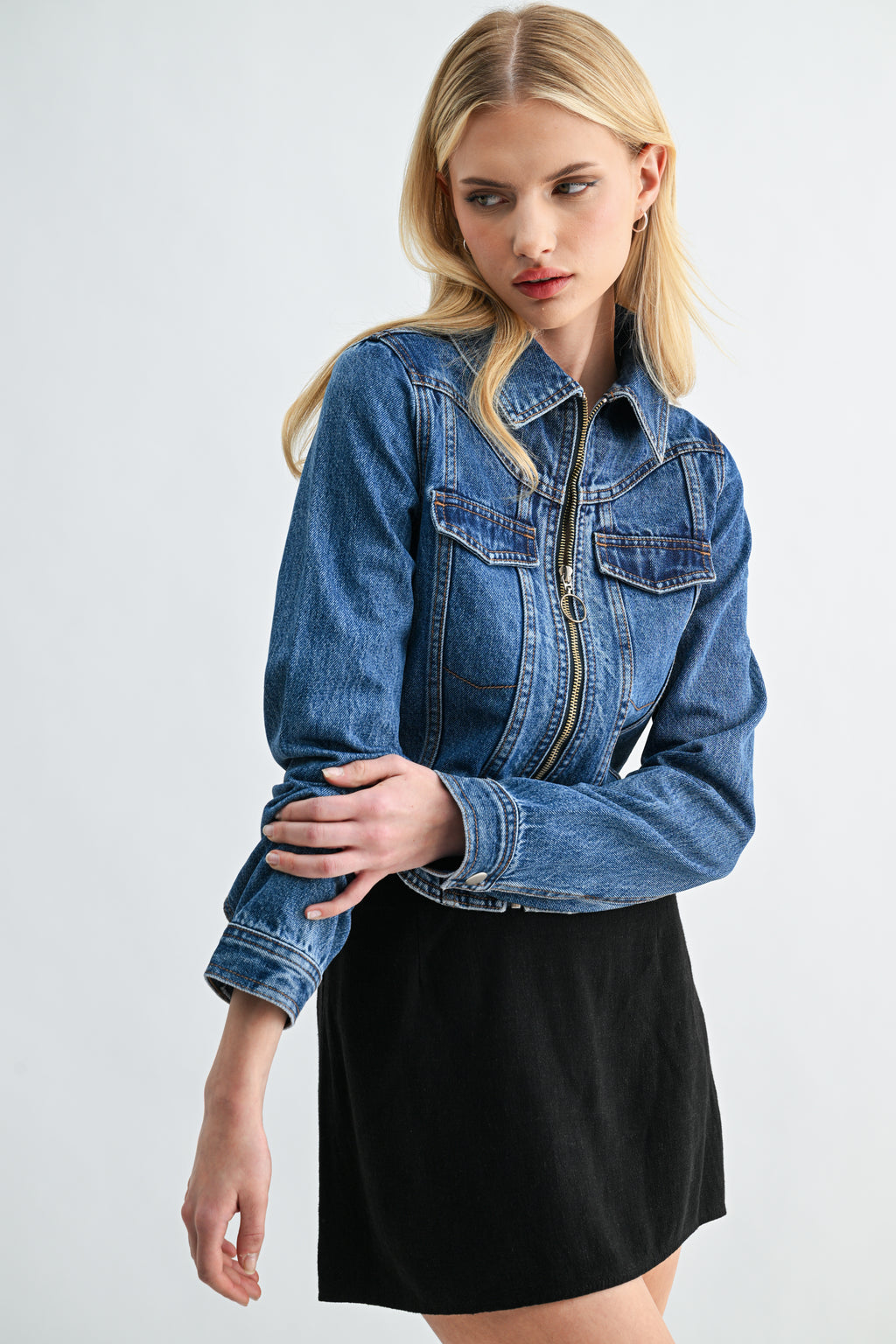 Model wearing cropped dark wash denim zip-front jacket