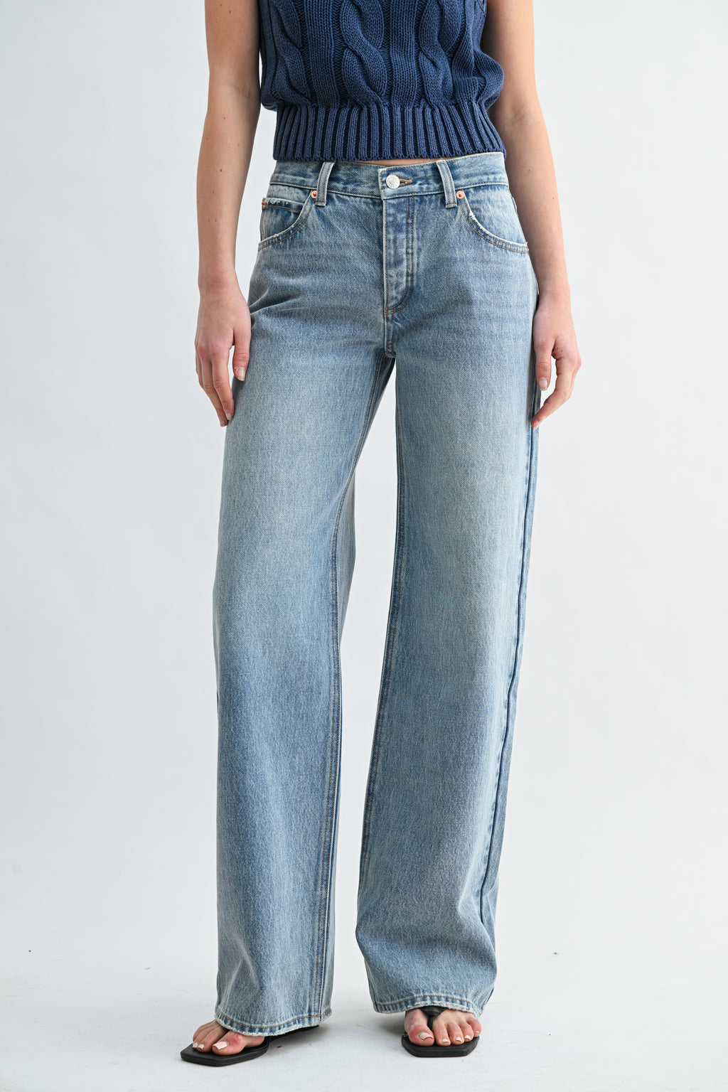 Close-up detail of low-rise waistband and vintage denim wash