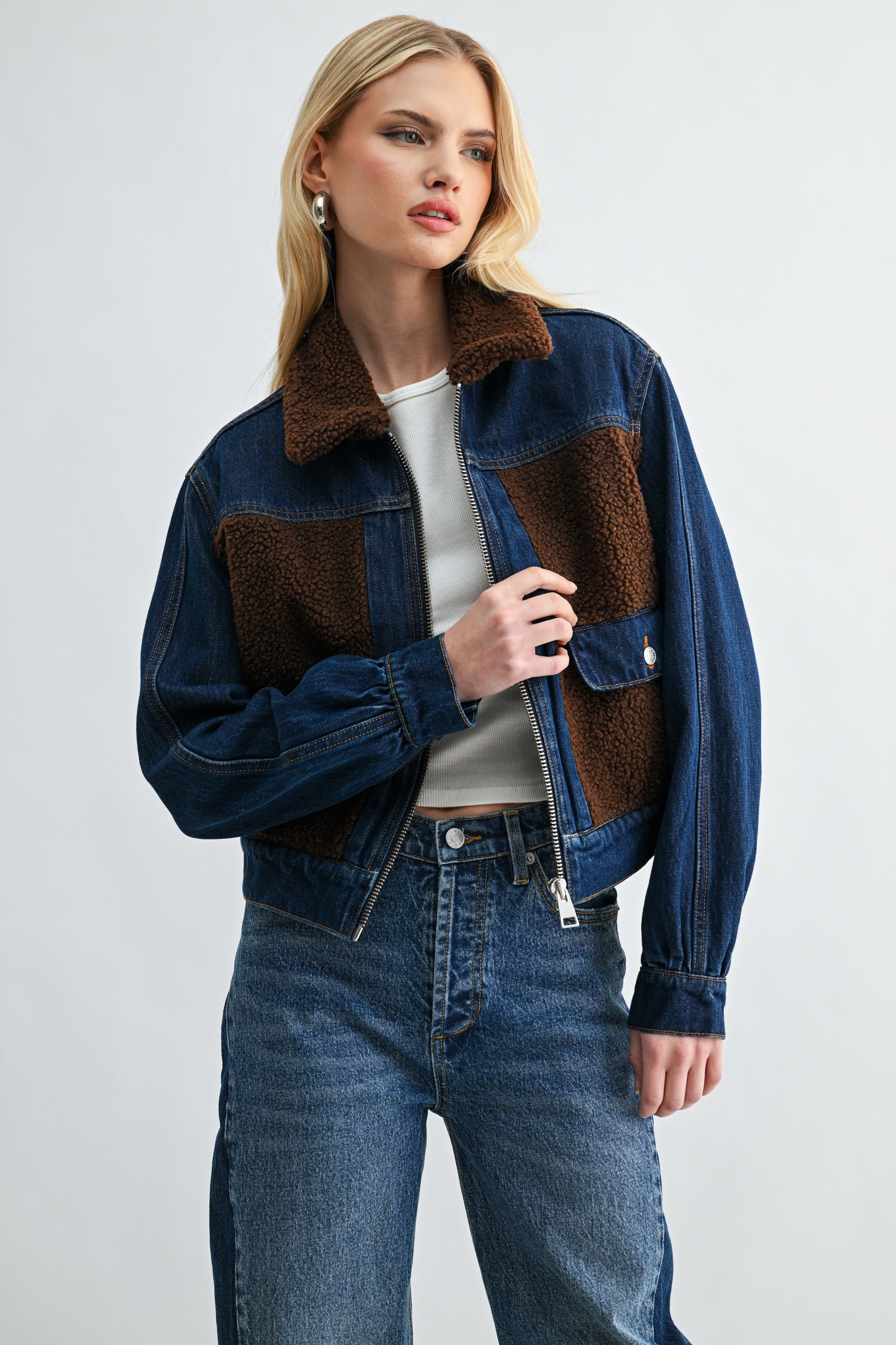 Model wearing two-tone dark wash denim jacket with warm sherpa lining