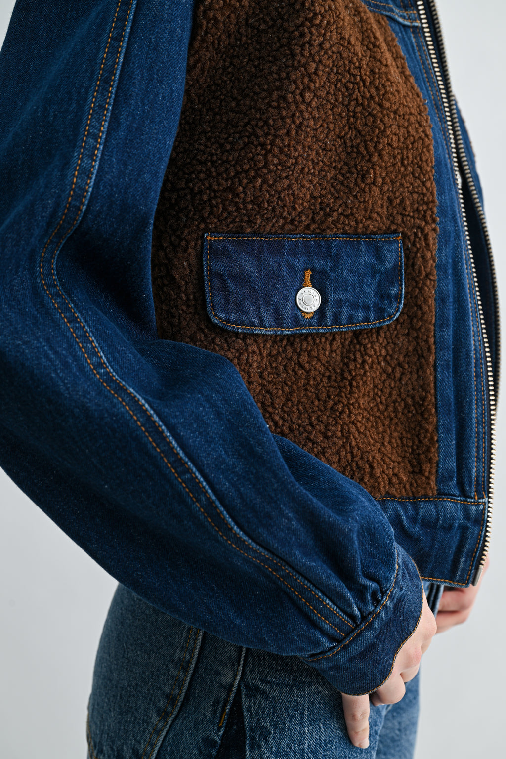 Close-up of sherpa collar detail and contrast dark wash denim panels