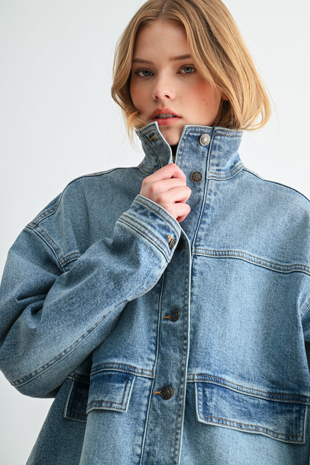 Model wearing oversized heavyweight denim jacket with modern mock neck collar