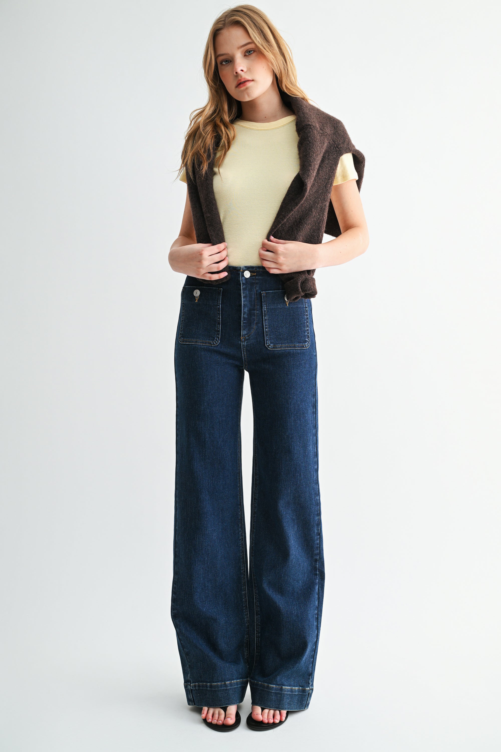 Front view of woman wearing high-rise straight-leg jeans with front patch pockets